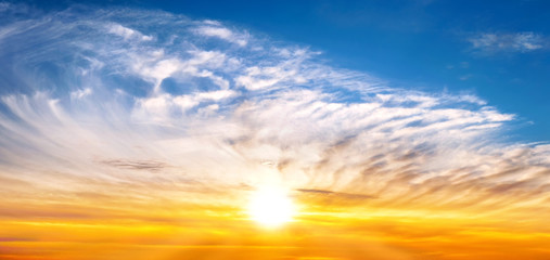 calm sunset sky landscape background natural color of evening cloudscape panorama with setting sun behind clouds wide panoramic view