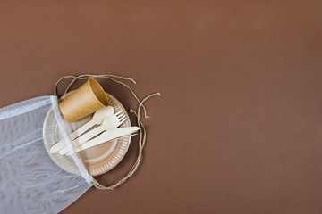 Zero waste, environmentally friendly, disposable, cardboard, paper utensils on a brown background. View from the top.
