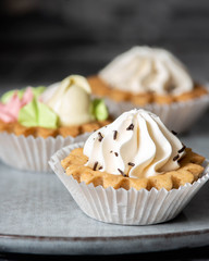 tart cakes with cream and chocolate chips on plate, cozy tea party