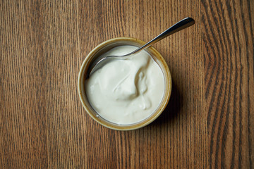 Classical Georgian cuisine sauce - Matzoon or matsoni yogurt with spices in a ceramic bowl on a wooden background