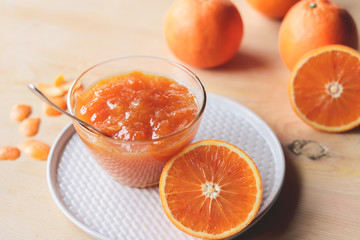 orange jam in a glass bowl on a white plate