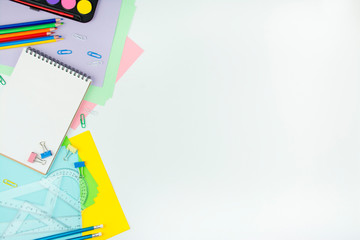 School supplies on a white background. Multicolored wooden pencils, notebook, paper clips, rulers, paper stickers. Office tools. Education concept copy space