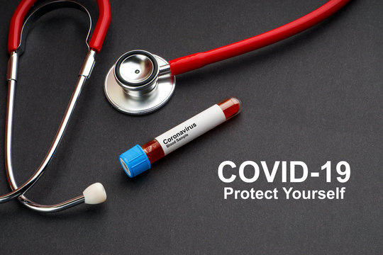 COVID-19 PROTEC YOURSELF text with stethoscope and blood sample vacuum tube on black background. Covid or Coronavirus Concept