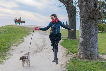 Naklejka na ściany i meble young woman taking her dog for a walk