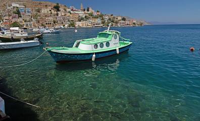 small fishing small fishing boat on the sea surface of the bay of Symi island, Greece