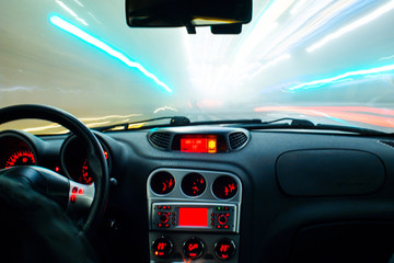 Night time car driving coloured city light streaks long exposure