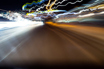 Abstract colorful dizzy car light trails taken at night on rural road from moving car