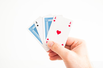 Play cards two Aces and two folded cards held in hand by Caucasian male hand