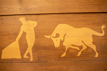 Illustration of bullfighter with bull on a wooden background