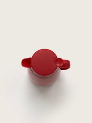 red thermos for hot water on a light background isolated top view