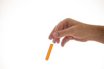 Glass cylindrical vial with orange brown liquid held by Caucasian male hand close up isolated on white