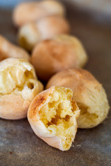 Pao di queijo small cheese breads fresh out of the oven front piece opened up shallow depth of field warm light