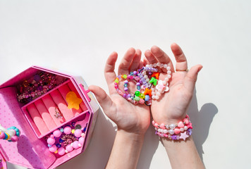bead bracelets. casket with beads in hands. decorations. bijouterie. hobbies of girls. rings. background