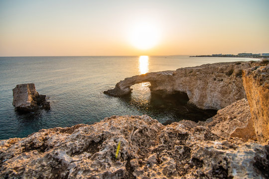 Beautiful sunset at natural stone bridge near Ayia Napa on Cyprus, Europe. Love bridge. Cavo greco