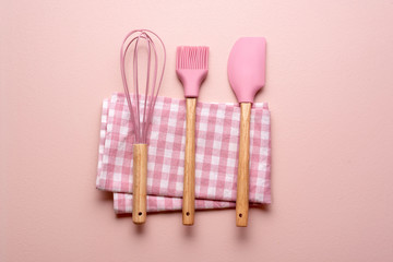 Kitchen utensils on a pink table. Colorful baking tools