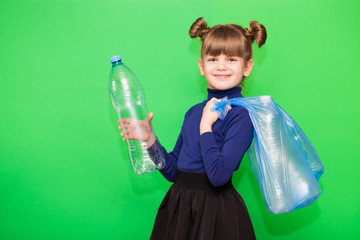 Positive little ecologist girl holding trash bag with plastic bottles and show thumb up isolated on green background
