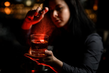 woman holds in one hand glass with alcoholic drink and sprinkles on it.