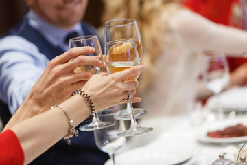 hands with four glasses of red wine close up. friends resting and drink cocktails in cafe. birthday party concept in the background close up. holiday mood concept