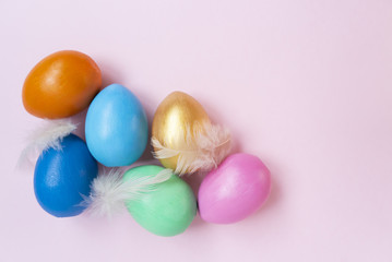 Pink, golden, orange, blue, green eggs. Copy space. Place for text and design. Top view. Flat layout.