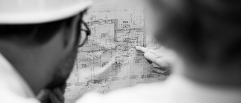 Architekten zeigen auf Grundriss