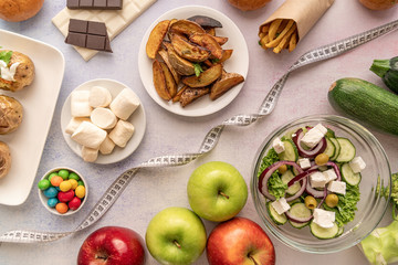 Fruit and vegetables vs sweets and potato fries top view flat lay