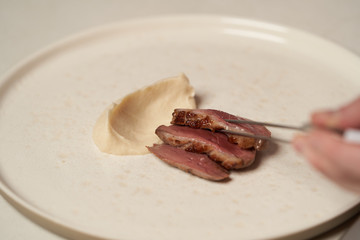 Chef cooking mashed potato and grilled duck breast