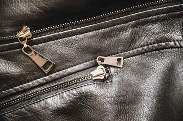 Metal zipper on a black women's jacket. Women's leather jacket top view. Black texture of genuine...