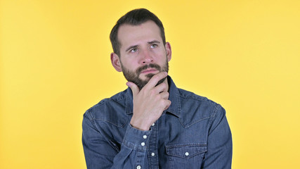 Obraz premium Portrait of Young Man Thinking about Idea, Yellow Background