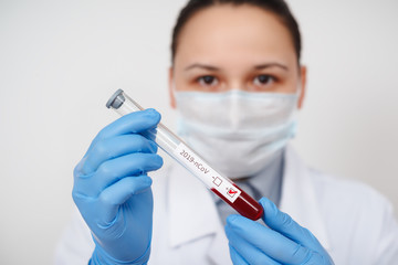 Blood test tube in doctor hand, Mers-CoV Coronavirus test Positive label in hospital blood test tube for analysis. 2019-nCoV virus infection originating in Wuhan, China