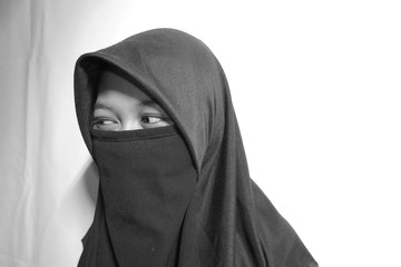 Naklejka premium Close up view of Pretty lady woman girl wear hijab jilbab niqab kerudung niqaab scarf cover face and only show visible look of her beauty eyes. Fit for put design life image. Black white with grain t