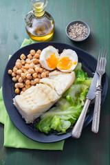 boiled cod fish with cabbage, chick pea and egg on dark dish