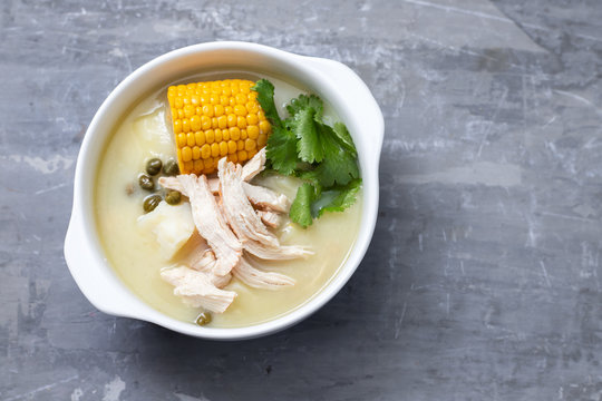 soup potato with corn and chicken in white bowl on ceramic background