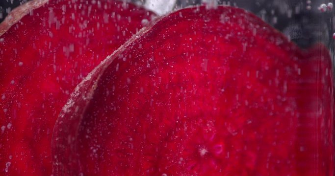 Fresh beets in water with air bubbles.