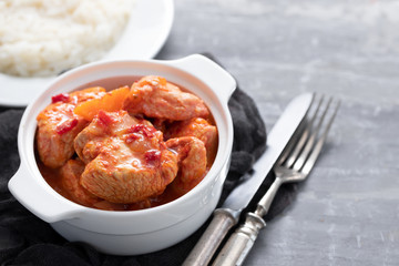 baked turkey meat in white bowl and boiled rice on white plate
