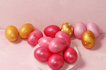 Decorated golden easter eggs on a pink background. Minimal holiday concept. Happy Easter...