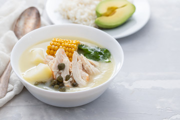soup potato with corn and chicken in white bowl on ceramic background