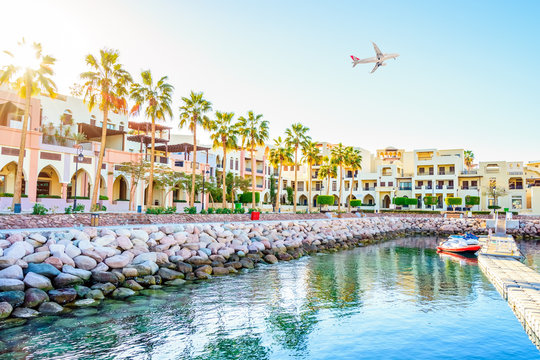 AQABA, JORDAN.  White passenger plane flying over the port of Aqaba located on Red Sea.