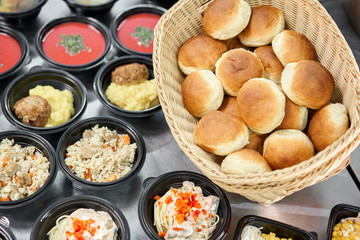 Row of plastic disposable lunch box with healthy natural food. Soups, cream soup, main course with side dish, salads. Food delivery. Lunch in the office.