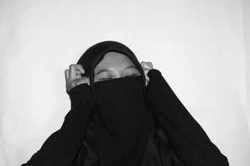 Close up view of Pretty lady woman girl wear hijab jilbab niqab kerudung niqaab scarf cover face and only show visible look of her beauty eyes. Fit for put design life image. Black white grain texture