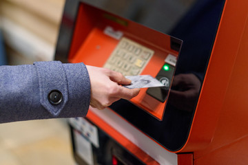 Feminine hand inserting card in ATM. Financial crisis concept.