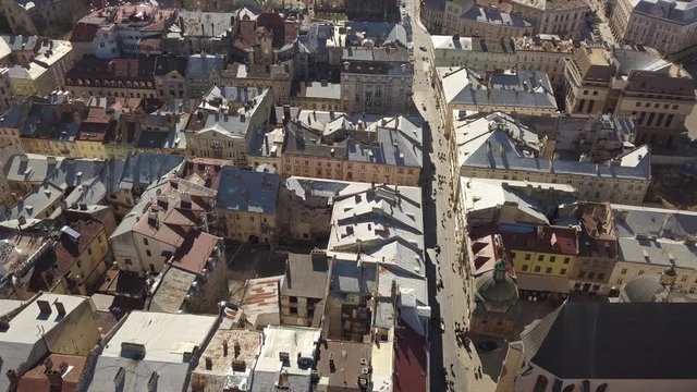 Aerial view to historic and tourist center of Lviv city from above. Roofs of historic buildings and roads with tourist on it, Ukraine