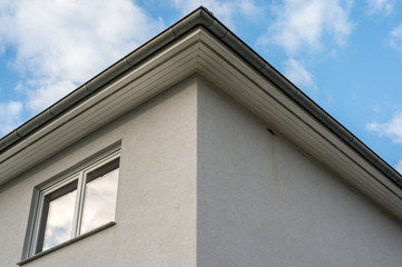Obergeschoss eines weißen verputzten Hauses mit Dachkasten und Doppelfenster