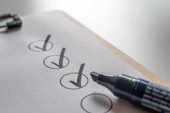 Abgehakte Checkliste mit schwarzem Stift als Hintergrund