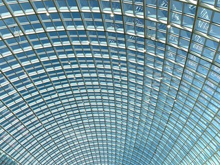 Glass roof, texture, view of the blue sky.