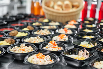 Row of plastic disposable lunch box with healthy natural food. Soups, cream soup, main course with side dish, salads. Food delivery. Lunch in the office.