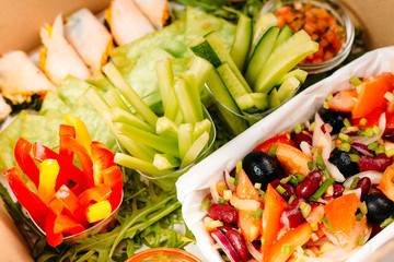 rolls of ham, vegetable mix ( pepper, cucumber, zucchini) arugula and salad of tomatoes, onion, beans, olives in containers for catering
