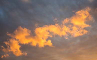 Low clouds are colorful illuminated by the light of the setting sun