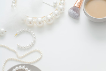 Jewelry for the bride, pearls, makeup brushes, delicate colors, candy and coffee, on a white background. Conceptual photography for weddings, preparation and morning of the bride.