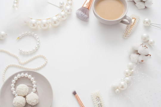 Jewelry for the bride, pearls, makeup brushes, delicate colors, candy and coffee, on a white background. Conceptual photography for weddings, preparation and morning of the bride.