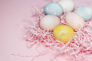 Fototapeta na wymiar Painted eggs in pastel colors on a pink paper filler and background. Modern easter holiday template